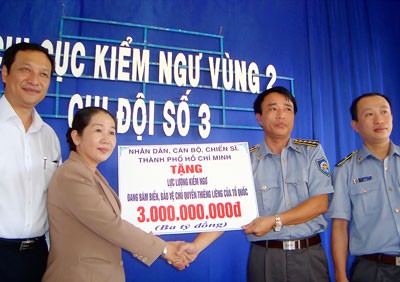 Vo Thi Dung (L) hands over VND3 billion to the Department of Fisheries Resources Surveillance in Da Nang May 18 (Photo: SGGP) Vo Thi Dung (L) hands over VND3 billion to the Department of Fisheries Resources Surveillance in Da Nang May 18 (Photo: SGGP)